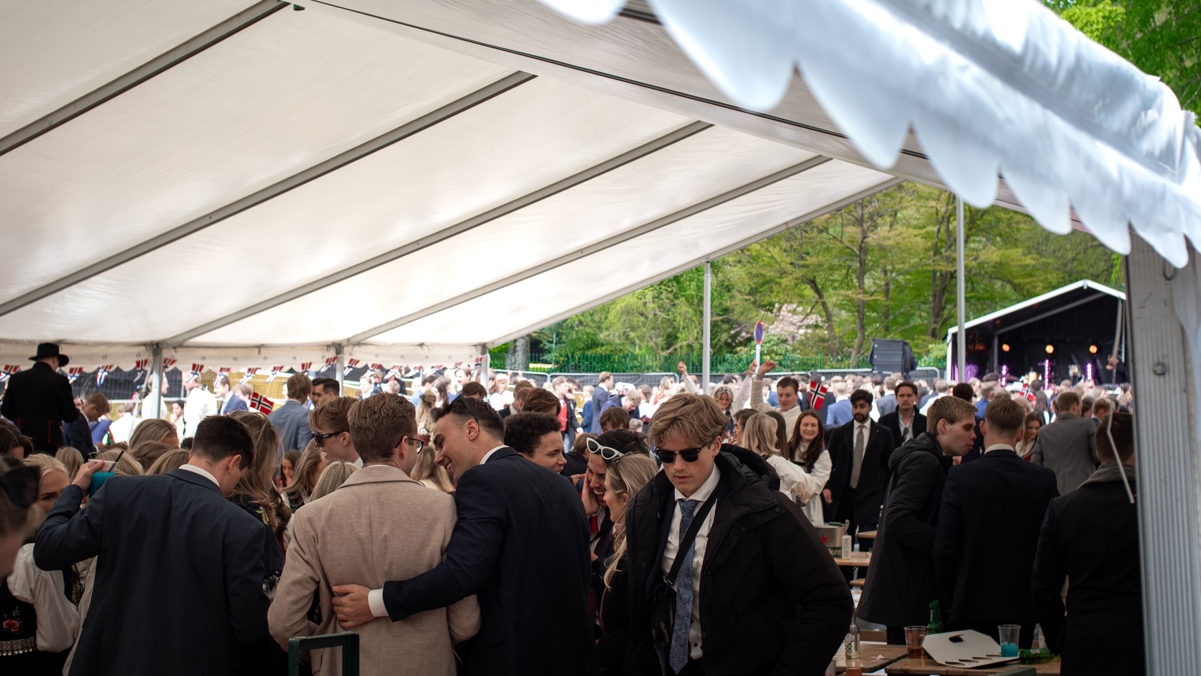 Festivalområde med toaletter til leie, toalettvogn til utleie, bord og benkesett, partytelt, bar og scene på Ja, vi Elsker Bergen arrangementet på Marinehallen 17. mai 2023