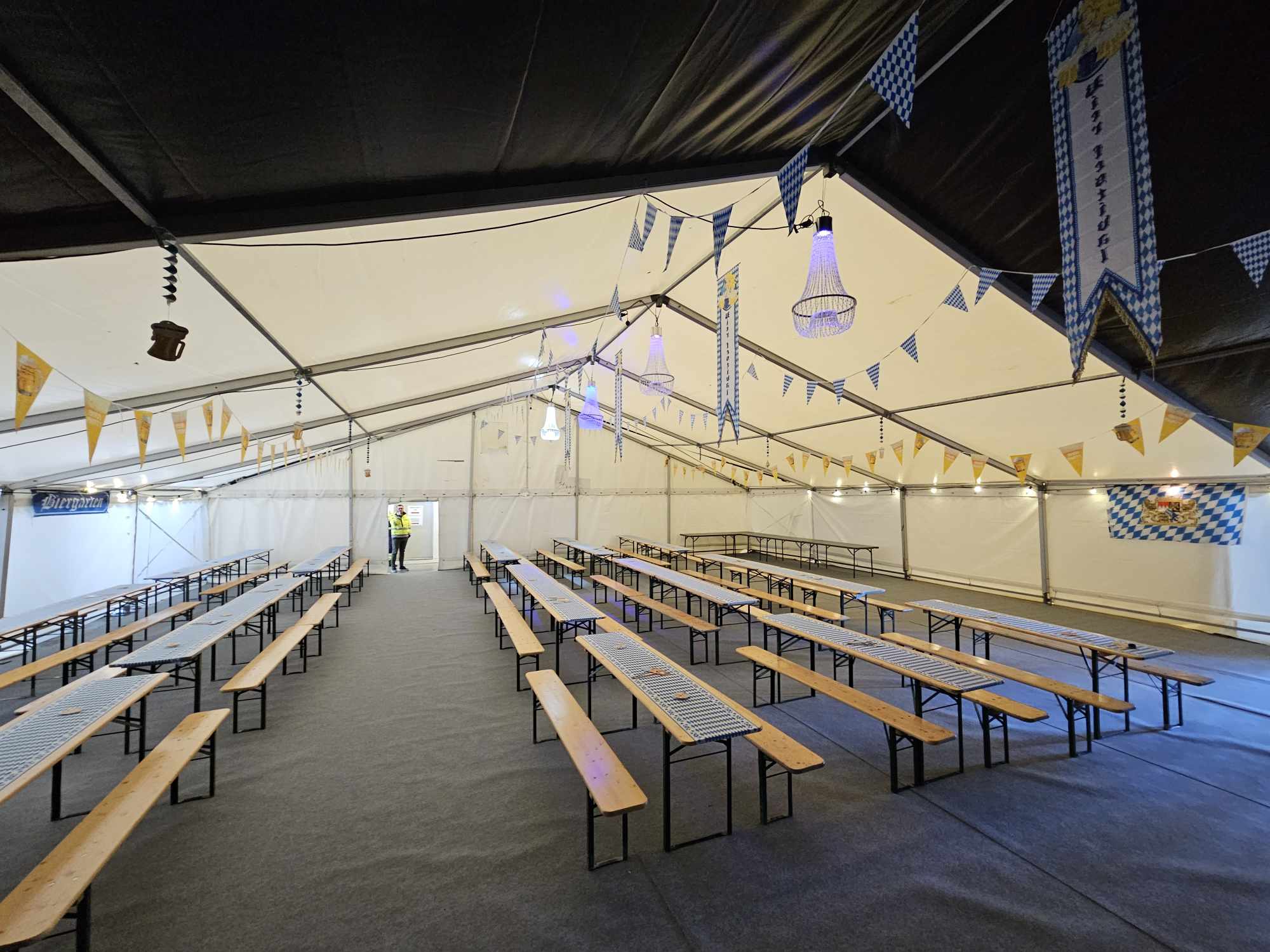 Stort partytelt med gulv, teppe, bord og benkesett, lysekroner, stoler og bord, toaletter, toalettbåser, festivaltoalett og toalettvogn